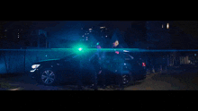 a man in a black jacket is standing in front of a green light
