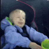 a little boy is sitting in a car seat