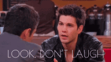 a man in a leather jacket talks to another man with the words " look don 't laugh " above him
