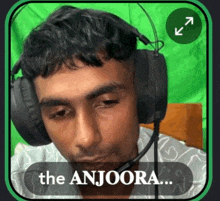 a man wearing headphones with the words the anjoora written below him