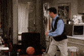 a man is dancing in a living room with a basketball and a poster on the wall that says night war forces