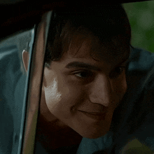 a close up of a man 's face looking out of a window