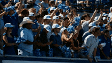 a crowd of people wearing pom poms and hats with the letter u on them