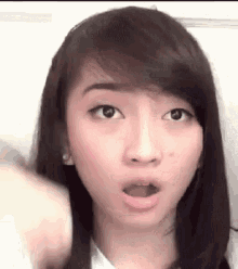 a close up of a woman 's face with her mouth open and a surprised look on her face .
