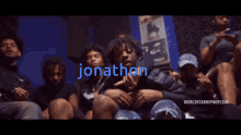 a group of young men are sitting in a room with the name jonathon written in blue