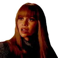 a woman with long red hair and bangs is wearing a black top