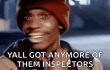 a man wearing a red beanie is smiling and says `` yall got anymore of them inspectors '' .