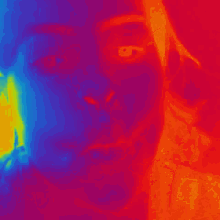 a close up of a person 's face with a rainbow of colors behind it