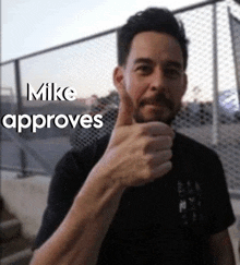 a man with a beard is giving a thumbs up .