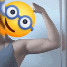 a person with a yellow smiley face on their face flexing their arm