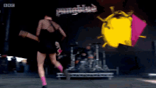 a woman playing a guitar on a stage with bbc written on the bottom