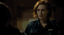 a woman in a police uniform is talking to another woman and the words what are visible
