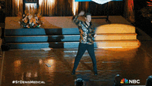 a man is dancing on a stage with a nbc logo in the corner