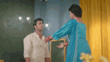 a woman in a blue dress is standing next to a man