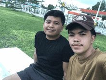 two men are posing for a picture and one has a hat that says reef wear squad on it