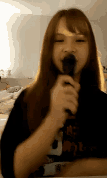 a girl is singing into a microphone in a room