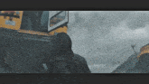 a person in a hooded jacket is standing in front of a school bus .