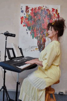 a woman in a yellow dress is sitting in front of a keyboard .