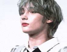 a close up of a person 's face with gray hair and red lipstick