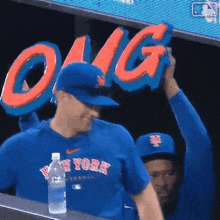 a man wearing a new york jersey holds up a sign that says omg