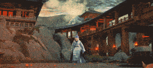 a man in a white robe is standing in front of a bridge with a building in the background