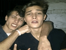 two young men are posing for a picture and one of them is making a face