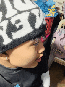 a little girl wearing a black and white hat that says " ice " on it