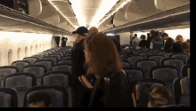 a group of people standing in a row of empty seats on an airplane