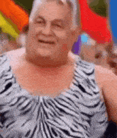 an older man wearing a zebra print tank top is smiling .