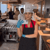 a woman in a chef 's hat is taking a selfie