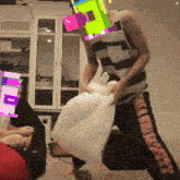 a man in a striped tank top is holding a white pillow while wearing a colorful mask