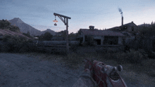 a person holding a gun in front of a building with a lantern hanging from a pole
