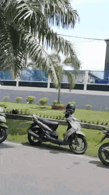 a scooter parked on the side of the road has a license plate that starts with a r on it