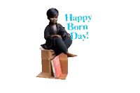 a woman is sitting on a cardboard box with the words happy born day