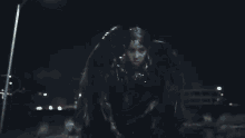a person covered in a black substance is standing in a dark street