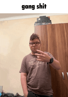 a young man taking a selfie with the words gang shit behind him