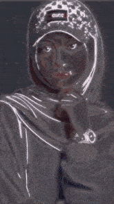 a woman wearing a hijab and a hat with gucci on it