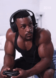 a man wearing headphones is playing a video game with the year 2018 in the corner
