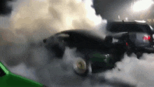 a green car is burning rubber and smoke is coming out of it 's tires .