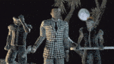 a man in a black and white plaid suit stands between two men