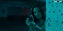 a woman holding a gun with a watermark that says pranay varha