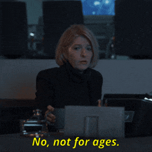 a woman sitting at a desk with the words " no not for ages " on the screen