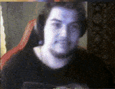 a man wearing headphones is sitting in a red chair