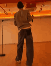 a man is standing in front of a microphone in a room .