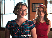 a woman in a plaid dress says " silly goose " next to another woman in a red dress
