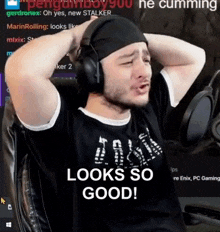a man wearing headphones is sitting in a chair with his hands behind his head and says looks so good .