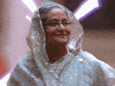 a woman wearing glasses and a veil is smiling for the camera