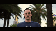 a man wearing a blue shirt that says " cool " on it