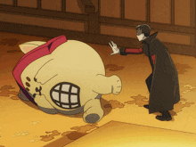 a man in a black coat is standing next to a stuffed animal with a large mouth