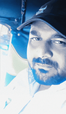 a man with a beard wearing a black hat with the word exit on it